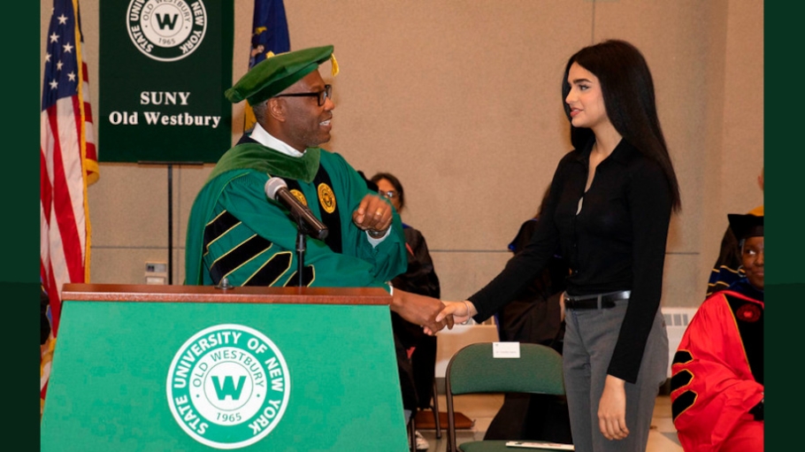 Photo of SUNY Old Westbury President Dr. Timothy Sams shaking hands with Pooja Aiyar