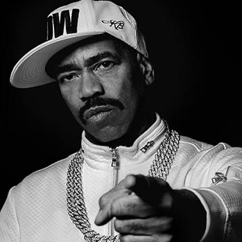 African American man with moustache wearing baseball cap and pointing at the camera