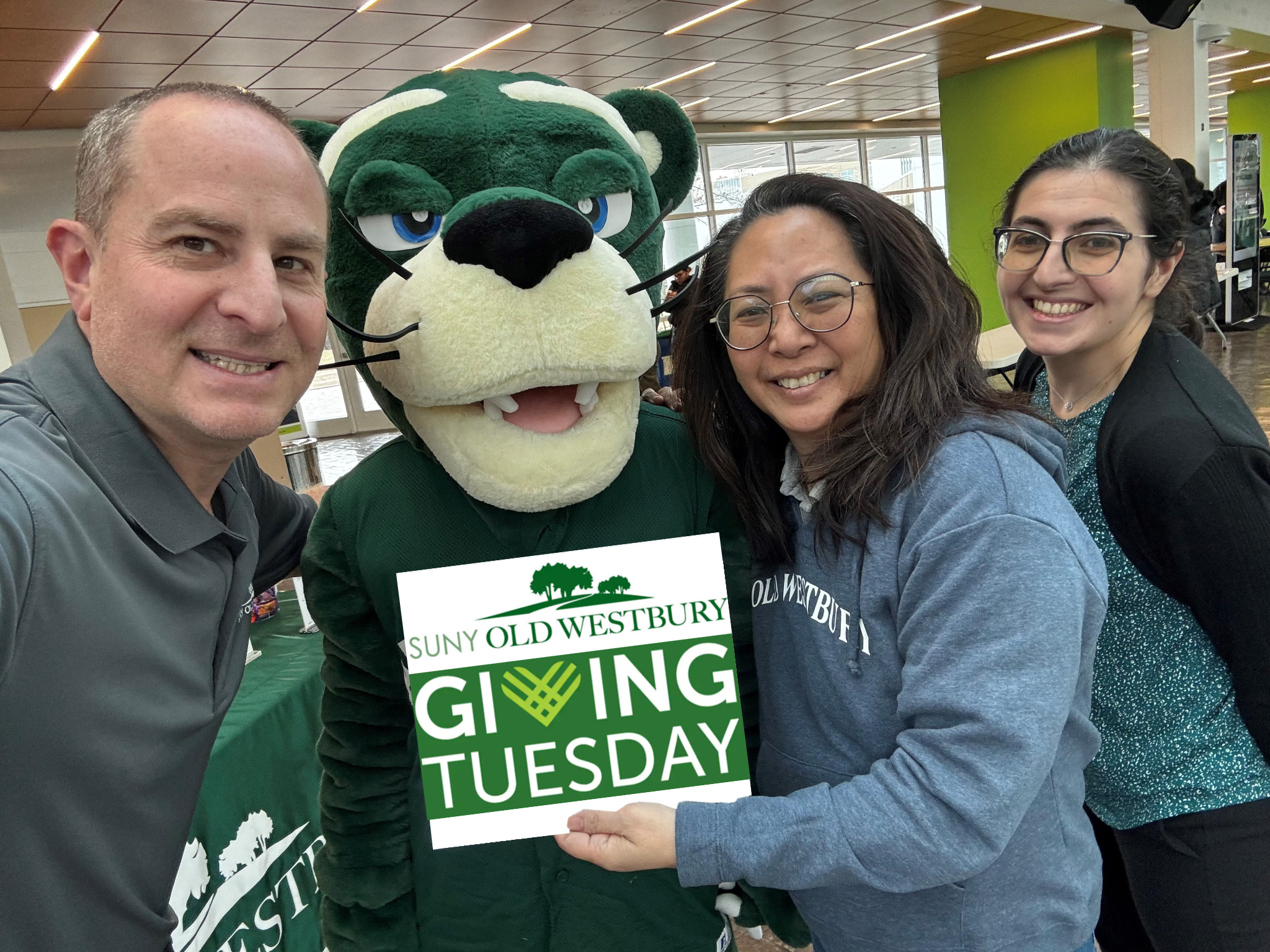 Staff members and Panther mascot holding Giving Tuesday sign