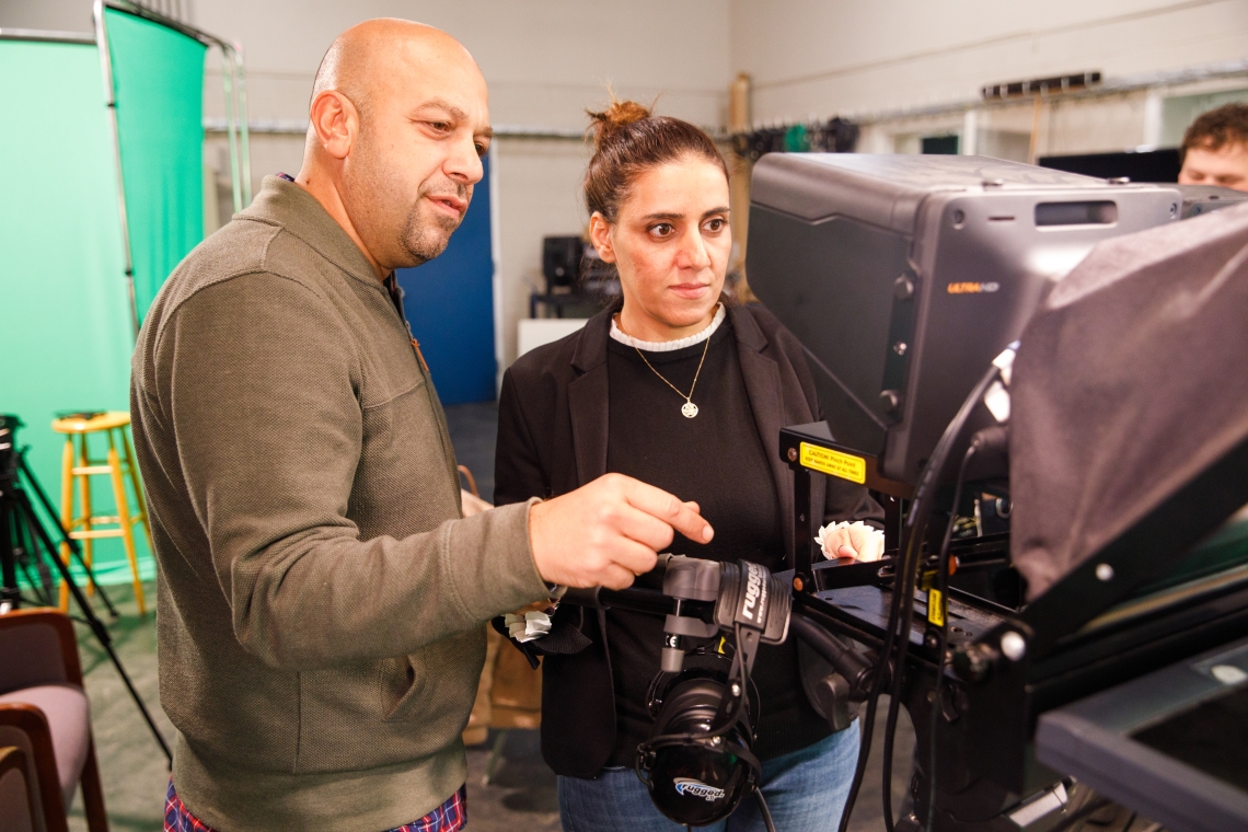 Instructor and student with camera in studio