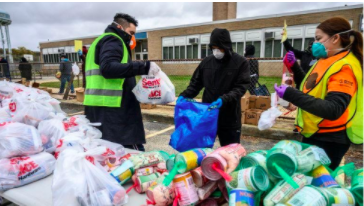 Three students bagging up donations