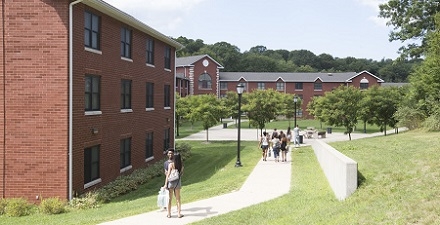 Students walking among the Woodlands Halls on a sunny day
