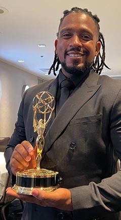 Class of 2000 graduate Kendall Rodriguez with his first Emmy® award for his work on the Newsday documentary “On The Shoulders of Giants.”  