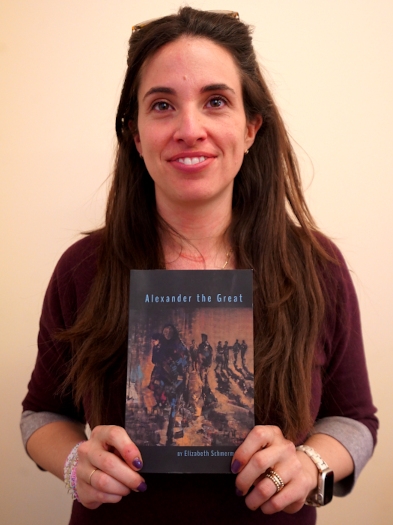 Photo of Professor Elizabeth Schmermund holding her new book "Alexander The Great"