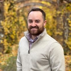 White man wearing beige 3/4-zip and collared shirt