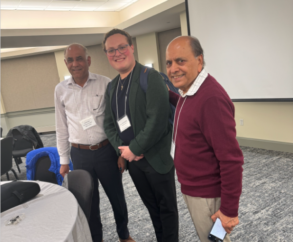 Two older South Asian men with a young white man