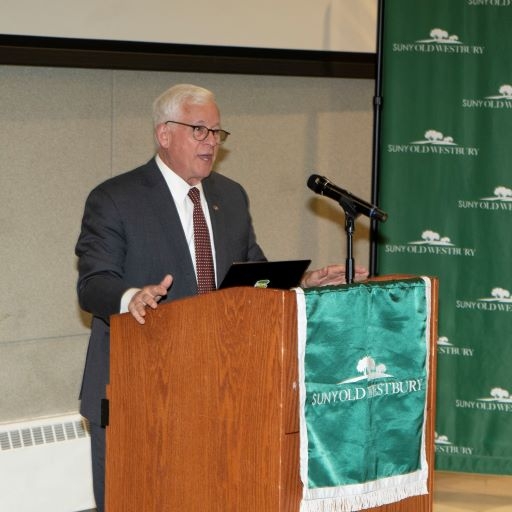 Man in suit speaking from a podium