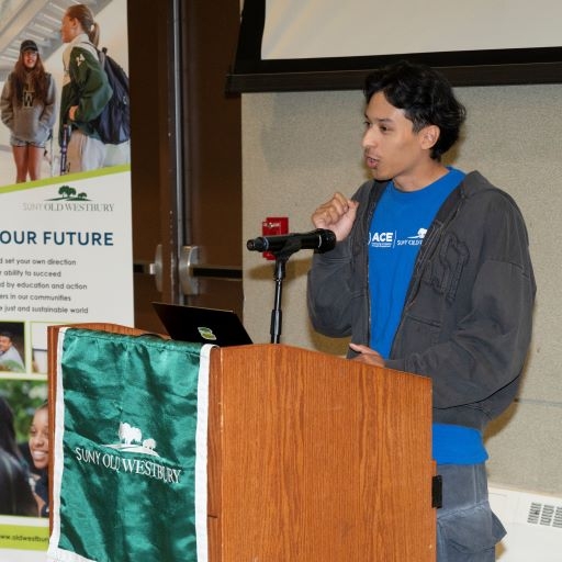 Young Hispanic man speaks from a podium