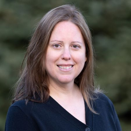 White woman with long hair with trees in the background