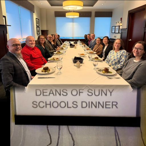 13 people sitting around a large table in a restaurant