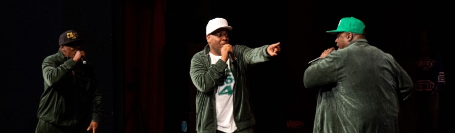 Three black men on stage performing