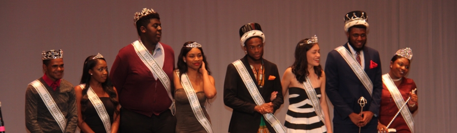Eight students on stage with crowns and sashes