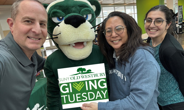 Staff members and Panther mascot holding Giving Tuesday sign