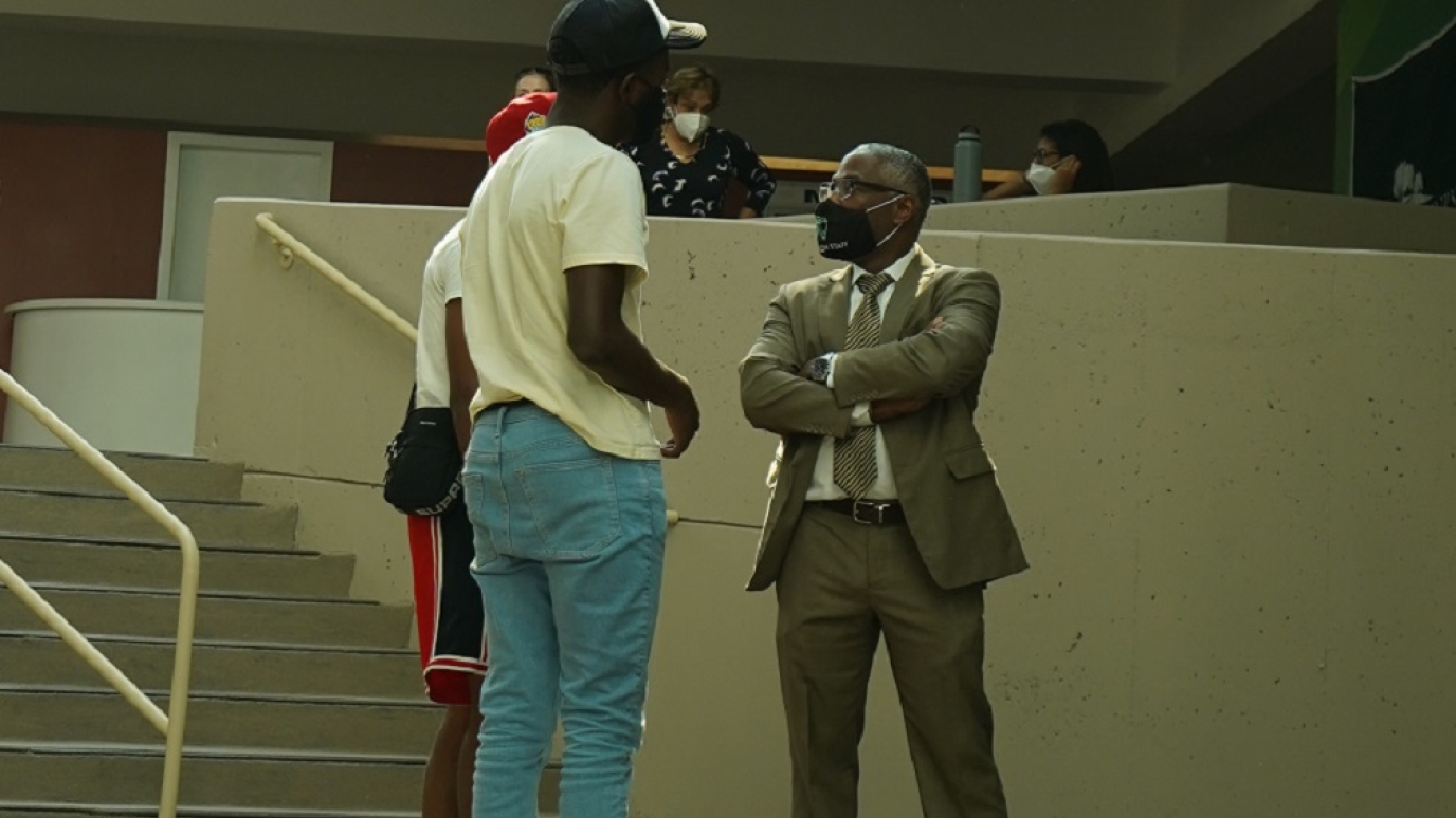 President Sams speaks with two male students in the Campus Center Atrium