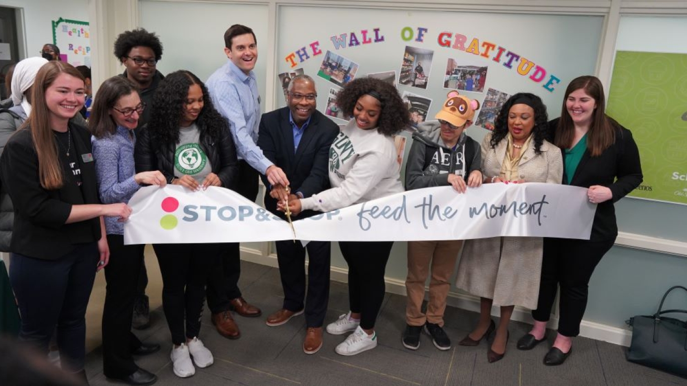 Ten people take part in a ceremonial ribbon cutting in the Panther Pantry