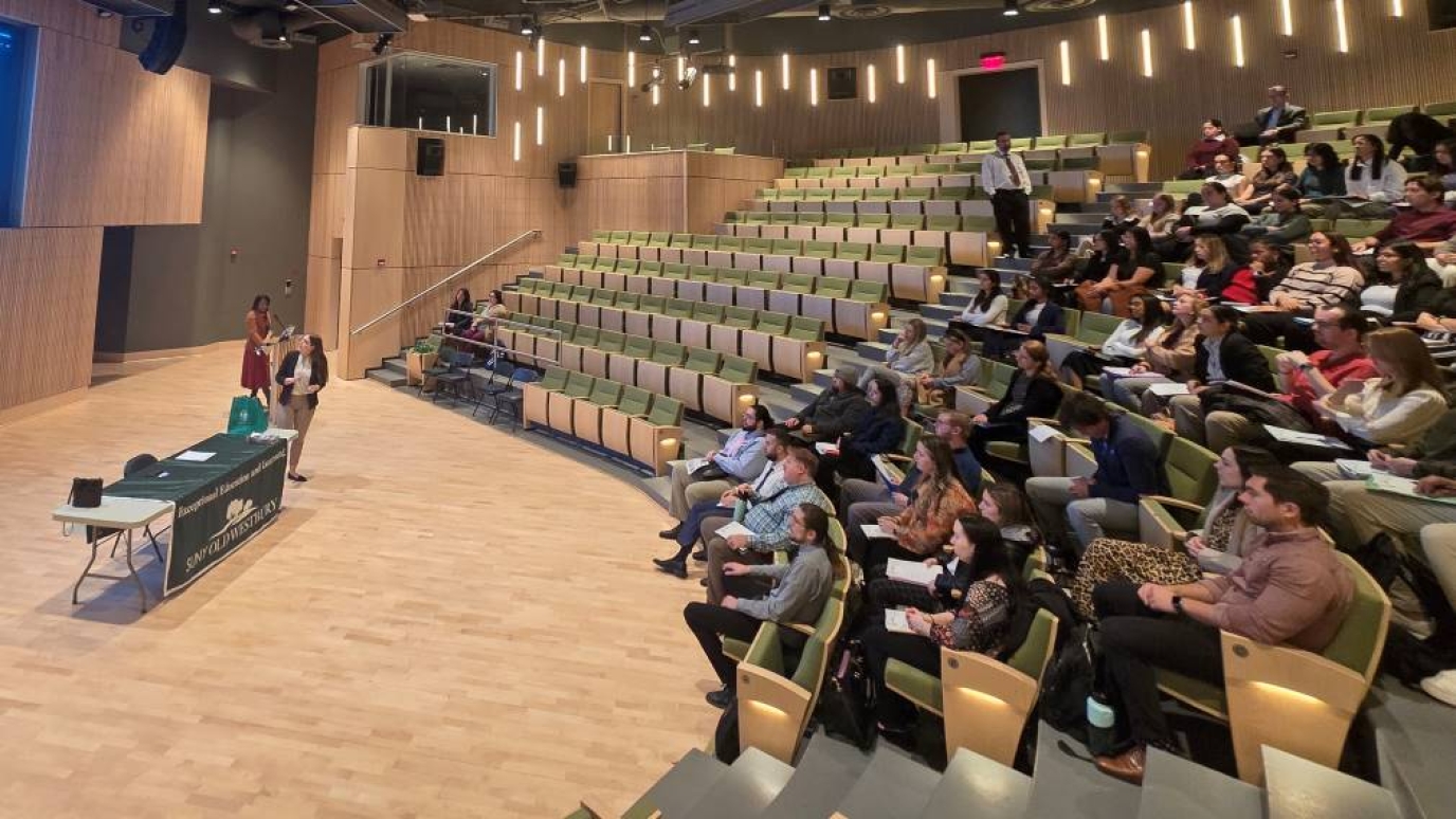 An audience gathers to hear from a female speaker