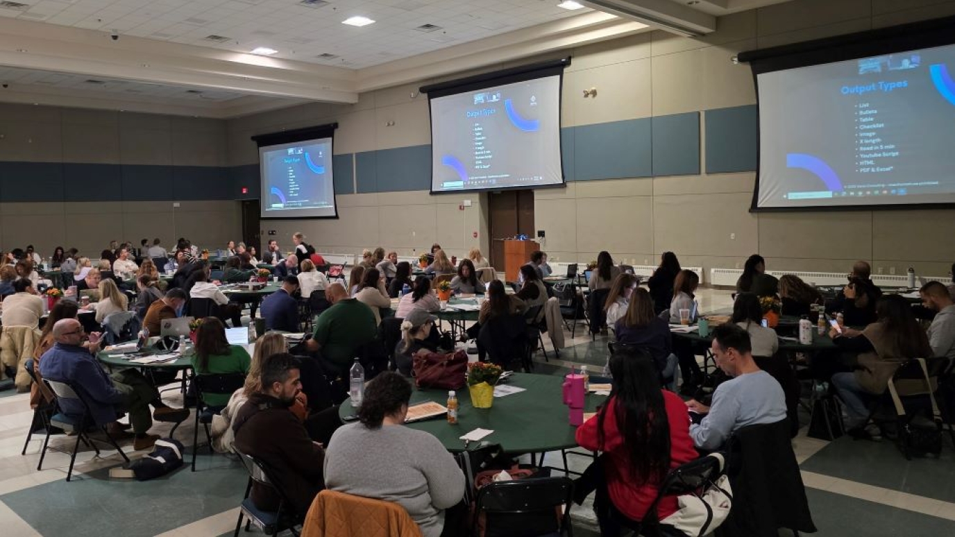 Large group of people sitting at round tables in a conference room