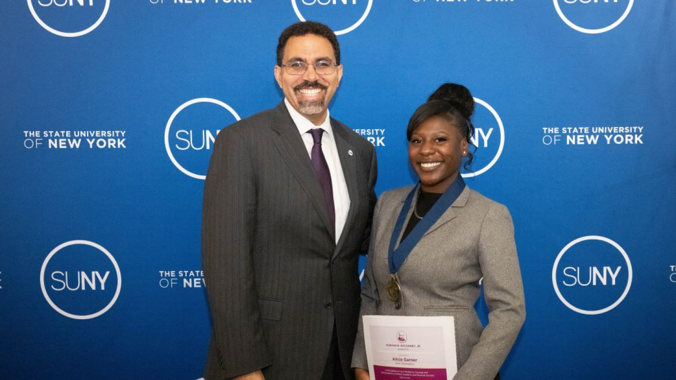 African American man presents award to African American woman