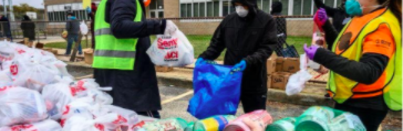 Three students bagging up donations