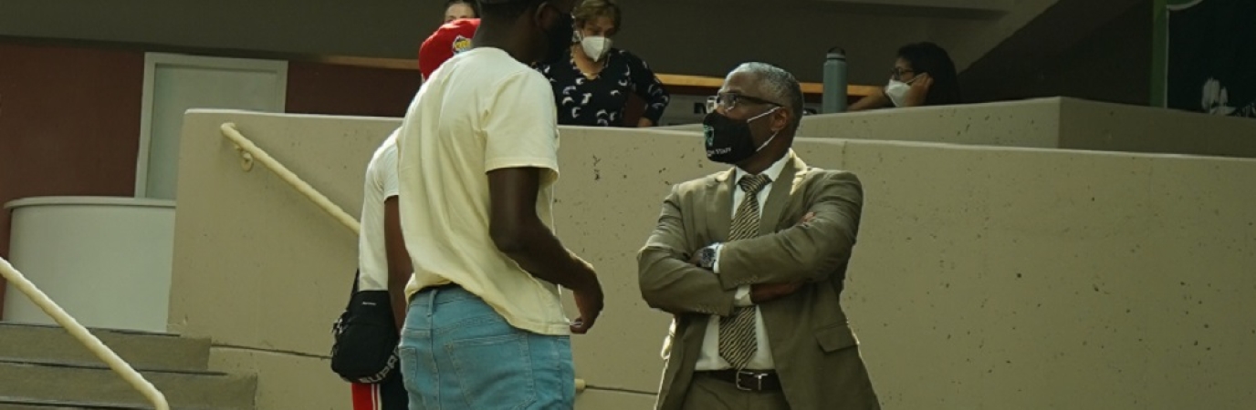 President Sams speaks with two male students in the Campus Center Atrium