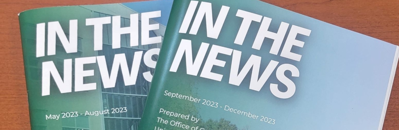 Two copies of the In The News booklet on a wooden counter