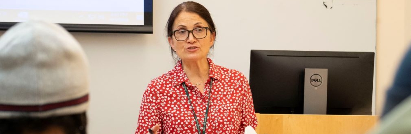 Professor in red blouse lecturing in class