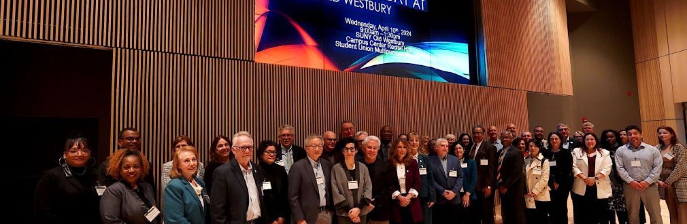 A group of 40 people standing below a screen that reads "BNL Day"