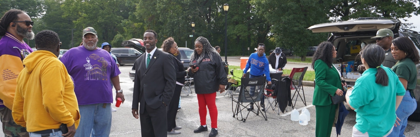 12 people in casual dress during a tailgating event