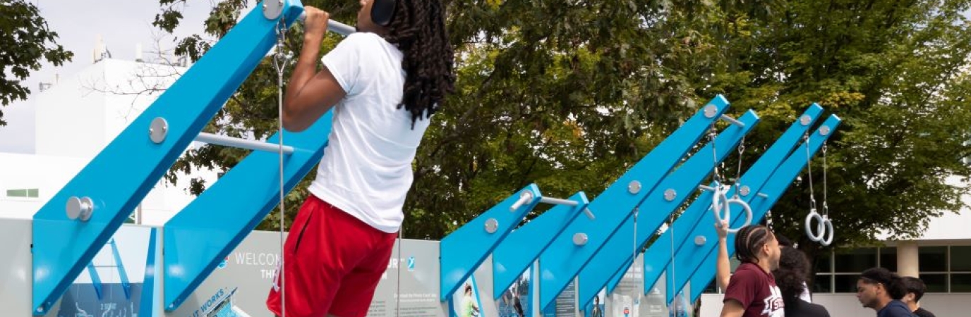 Three students exercising on the outdoor fitness court
