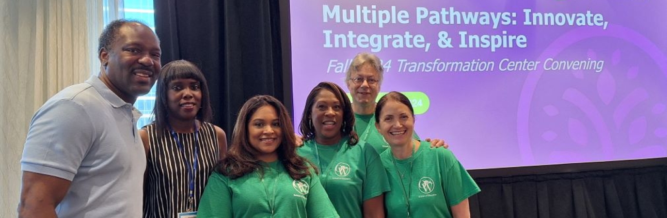 Five professionals stand before a sign reading "Multiple Pathways: Innovate, Integrate & Inspire"