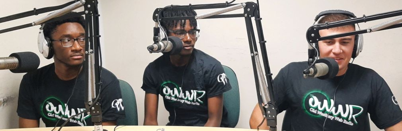 Three students at microphones with headphones on