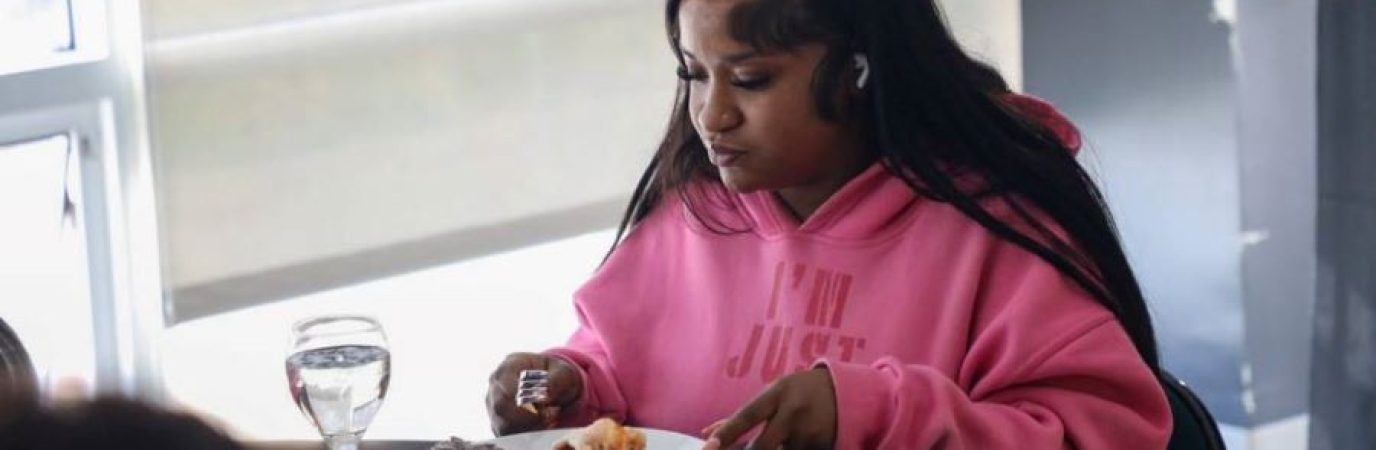 Young black woman dines on lobster