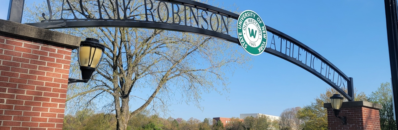 Iron sign reading Jackie Robinson Athletic Conference hung between two brick columns.