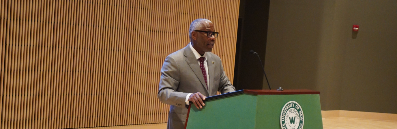 President Dr. Sams speaking at a podium