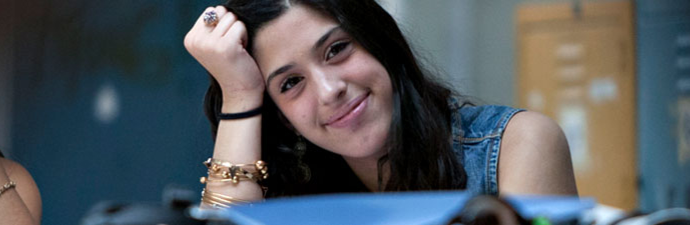 Smiling young woman leaning her head against her hand