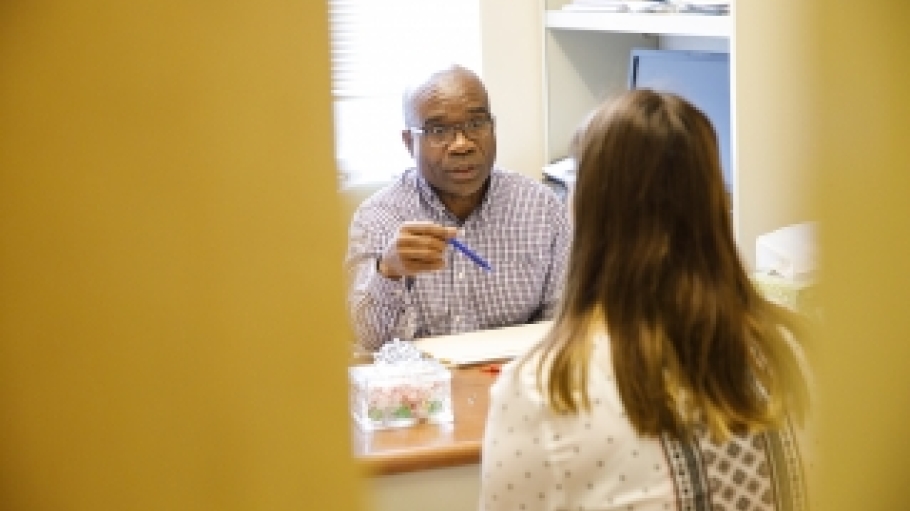 Childhood education professor Blidi Stemn talking to a student