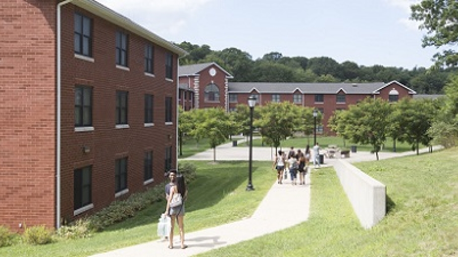 Students walking among the Woodlands Halls on a sunny day