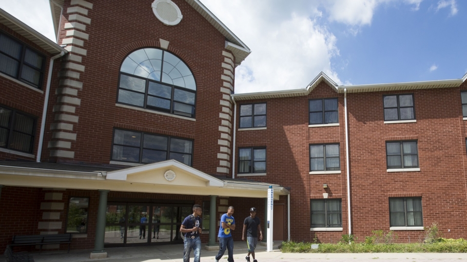 Three students walking outside a Woodlands Residence Hall