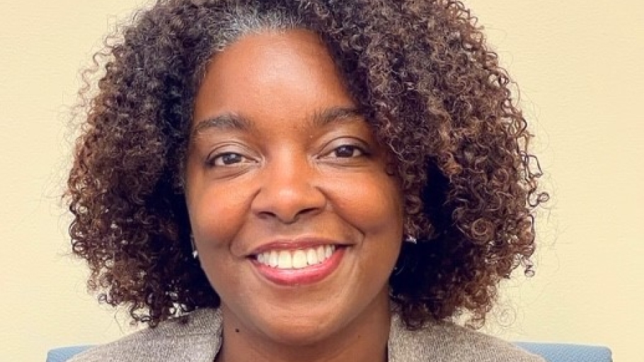 Headshot of Shalei Simms in a taupe blazer and navy shirt