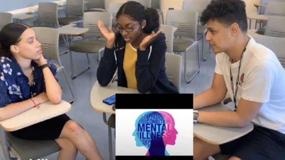 Three students in a classroom in a small-group discussion