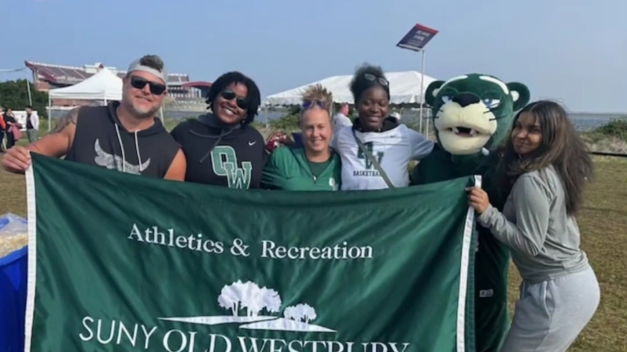 Four athletes and coaches stand with mascot OWWIN holding a campus banner