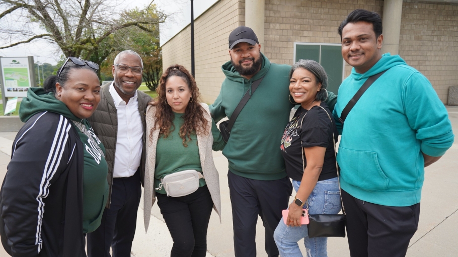 Five alumni with President Sams outside the Clark Center