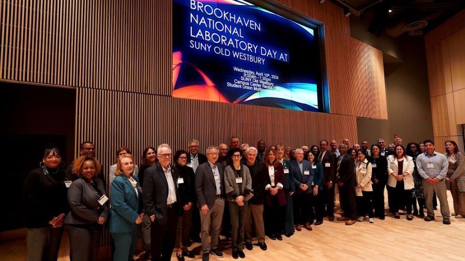 A group of 40 people standing below a screen that reads "BNL Day"