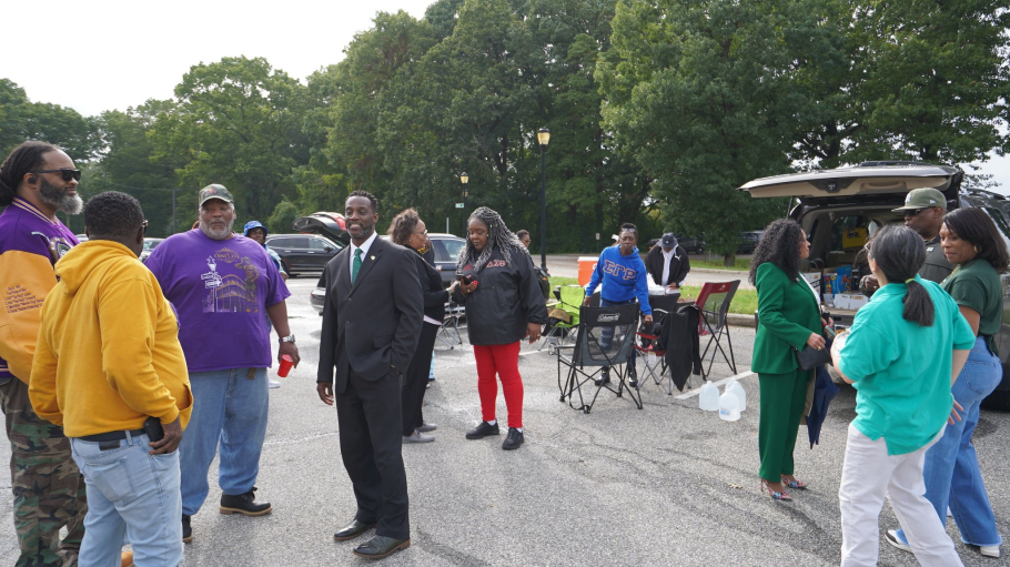 12 people in casual dress during a tailgating event