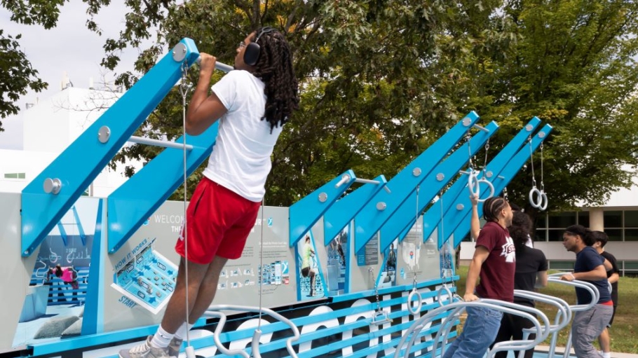 Three students exercising on the outdoor fitness court