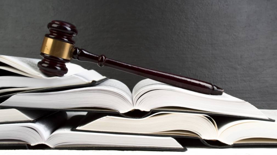 A gavel laying on a stack of opened books