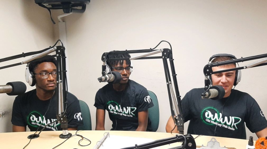 Three students at microphones with headphones on