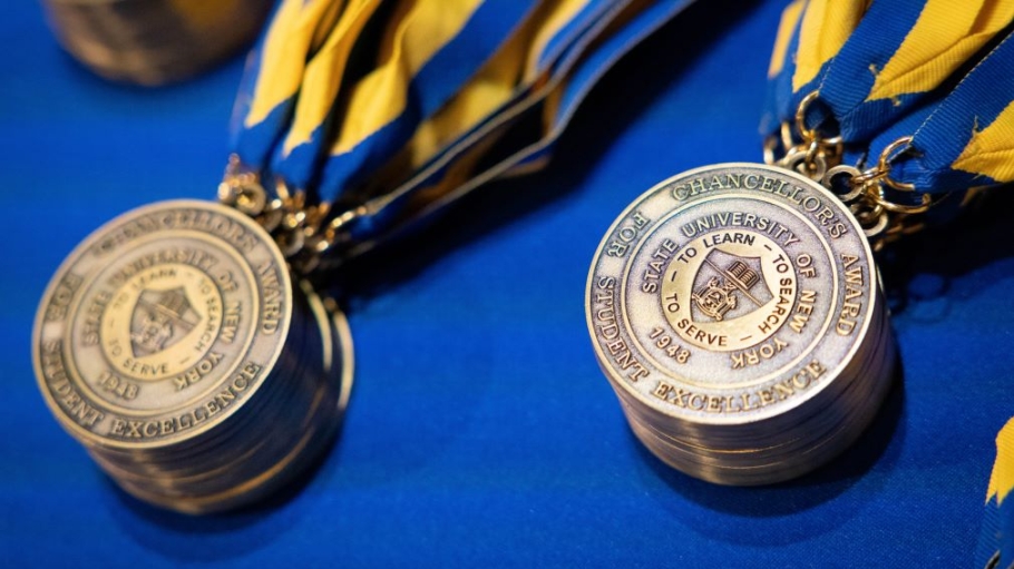 Stacks of bronze award medals hung from blue and yellow ribbons