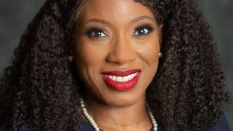 African American woman in blue suit with pearl necklace