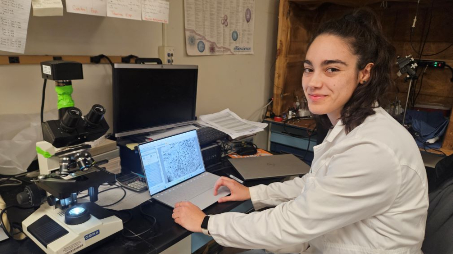 Hispanic woman in lab coat using scientific equipment